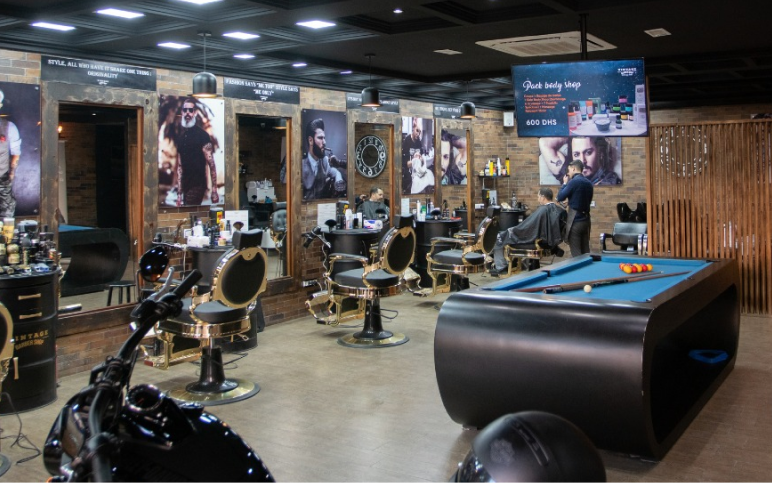 Inside The Vintage Barber: gold barber chairs, mirrors, a pool table and a motorbike
